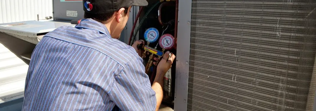 HVAC technician servicing a condenser unit in Woodhaven