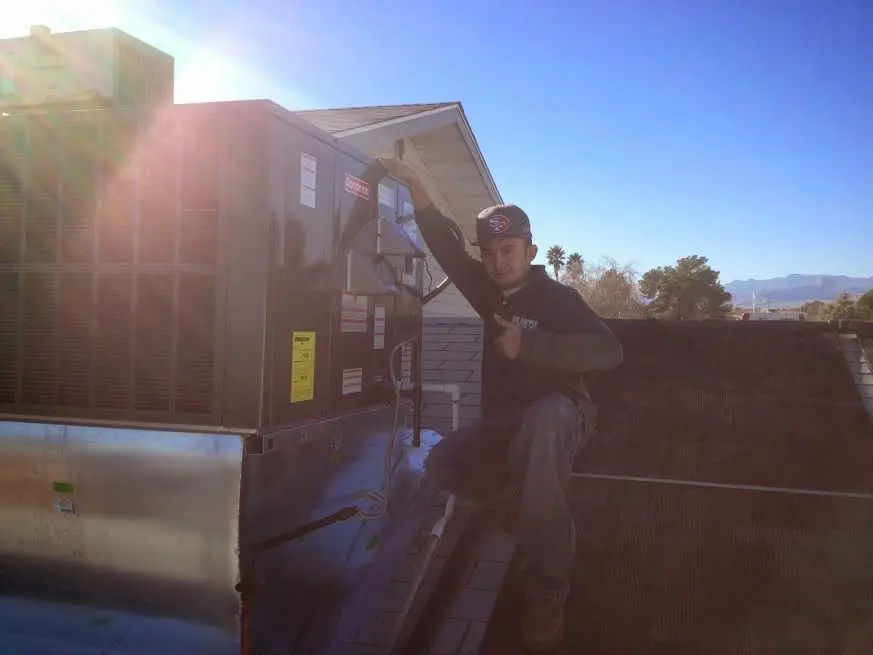 HVAC technician performing AC Tune-Up on a rooftop unit in Woodhaven